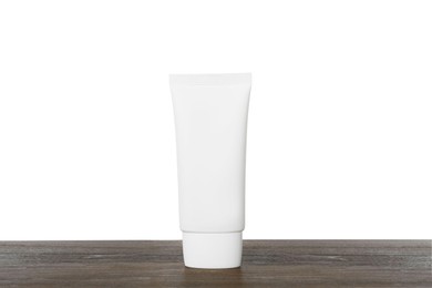 Tube of hand cream on wooden table against white background