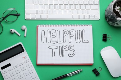 Photo of Helpful Tips. Flat lay composition with notebook, calculator and computer keyboard on green background