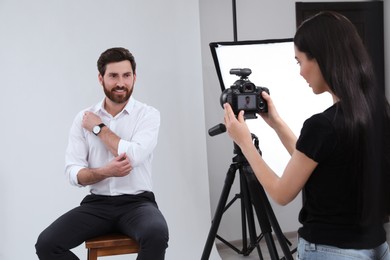 Photo of Professional photographer working with handsome model in modern photo studio