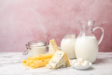 Fresh dairy products on table against color background