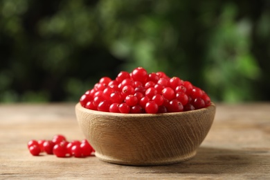 Ripe fresh cranberry in bowl on wooden table