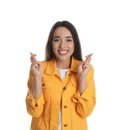 Excited young woman holding fingers crossed on white background. Superstition for good luck 