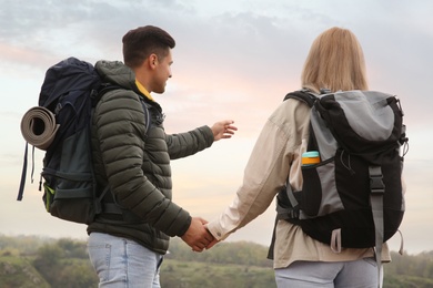 Photo of Couple of travelers with backpacks enjoying beautiful view of nature. Autumn vacation