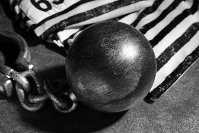 Prisoner ball with chain on grey table, closeup