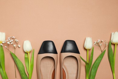Photo of Flat lay composition with pair of new stylish square toe ballet flats and beautiful flowers on beige background. Space for text