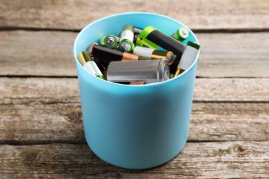 Image of Used batteries in bucket on wooden table