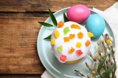 Beautiful Easter cake and painted eggs on wooden table, flat lay