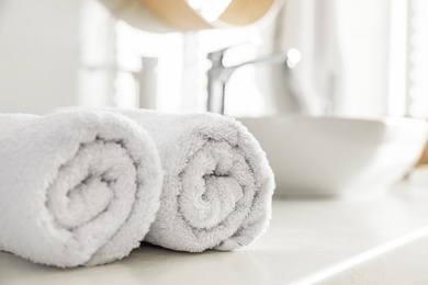 Clean rolled towels on countertop in bathroom