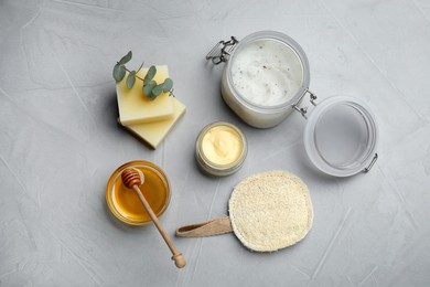 Flat lay composition with beeswax and cosmetic products on light grey stone table