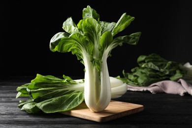 Fresh green pak choy cabbages on black wooden table