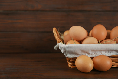 Raw chicken eggs on wooden table. Space for text
