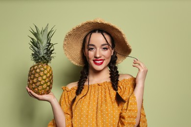 Photo of Young woman with fresh pineapple on olive background. Exotic fruit