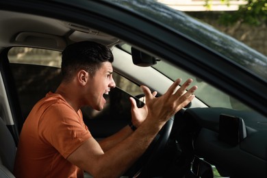 Stressed man in driver's seat of modern car