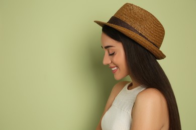 Beautiful young woman wearing straw hat on olive  background, space for text. Stylish headdress