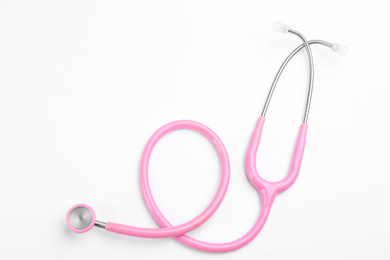 Pink stethoscope isolated on white, top view. Breast cancer awareness