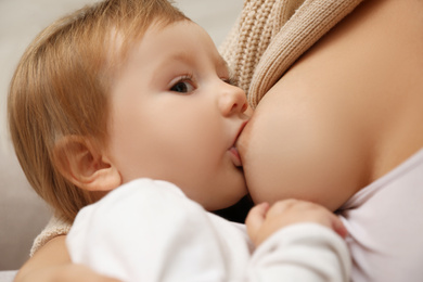 Woman breastfeeding her little baby, closeup view