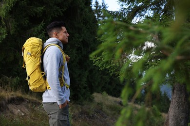 Tourist with backpack in forest, space for text