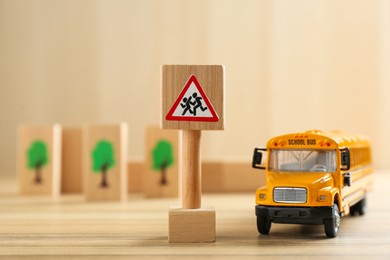 Traffic sign Attention children crossing street and toy bus on wooden table. Passing driving license exam