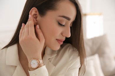 Woman with luxury wristwatch on blurred background
