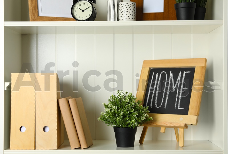 White shelving unit with chalkboard and decorative elements