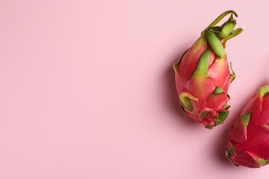 Photo of Delicious pitahaya fruits on light pink background, flat lay. Space for text