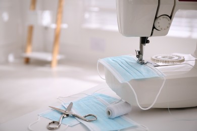 Sewing machine with disposable face mask on table indoors, space for text