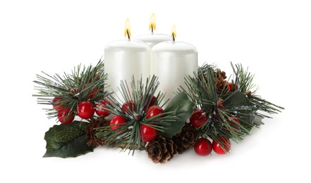 Burning candles with Christmas decor isolated on white