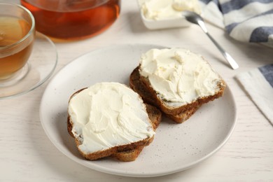 Photo of Bread with cream cheese on white wooden table