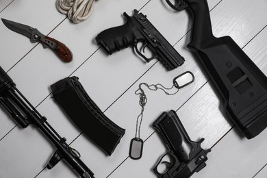 Flat lay composition with different guns on white wooden background