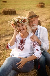 Happy mature couple wearing Ukrainian national clothes in field