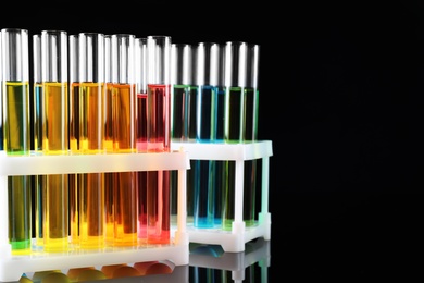 Test tubes with colorful liquids on black background
