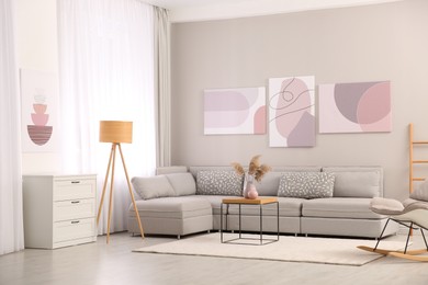 Stylish living room interior with big comfortable sofa and pictures