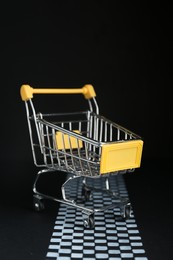 Photo of Competition concept. Yellow shopping cart on finish line