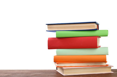 Stack of colorful books on wooden table against white background