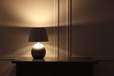 Stylish glowing night lamp on table in room. Space for text