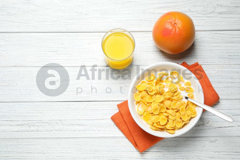 Photo of Flat lay composition with tasty corn flakes on white wooden table. Space for text