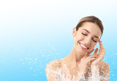 Portrait of beautiful young woman with perfect moisturized skin and splashing water, space for text