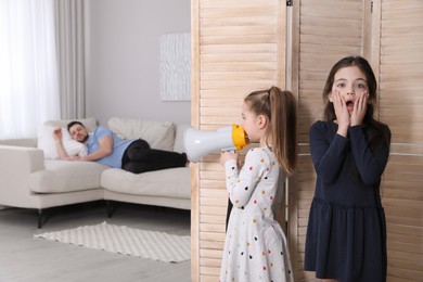 Cute little children with megaphone waking up their father at home