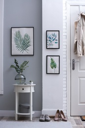 Vase with fresh eucalyptus branches on table in entryway. Interior design