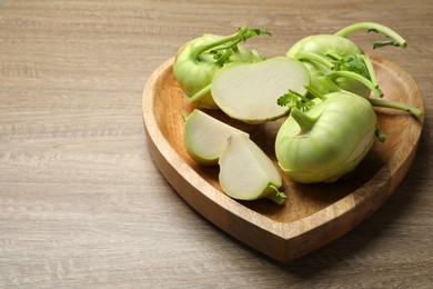 Photo of Whole and cut kohlrabi plants on wooden table