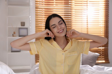 Woman sitting on comfortable bed with new linens