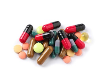 Pile of different colorful pills on white background, above view