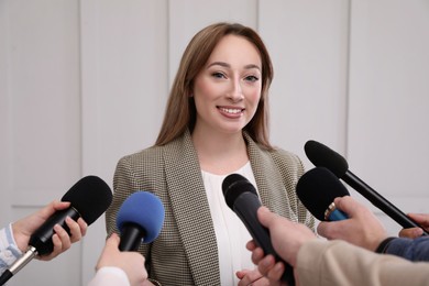 Happy business woman giving interview to journalists at official event