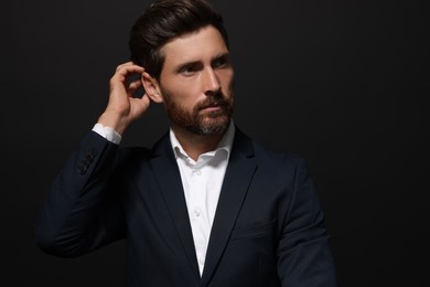 Photo of Portrait of handsome bearded man looking away on black background. Space for text