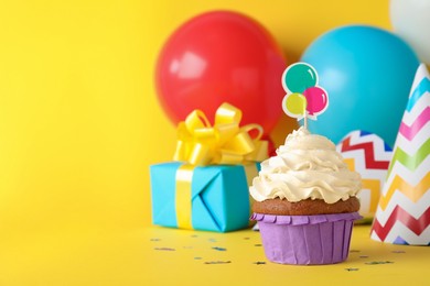 Delicious birthday cupcake on yellow background, space for text