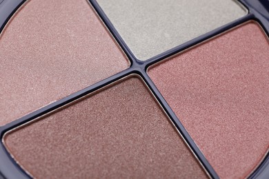 Photo of Colorful contouring palette as background, closeup. Professional cosmetic product