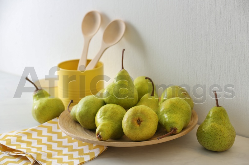 Photo of Plate with fresh ripe pears on white table
