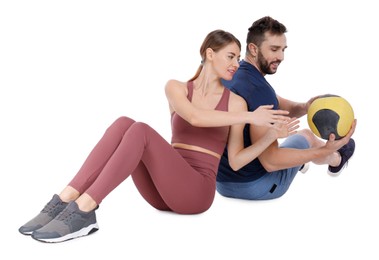 Athletic couple doing exercise with medicine ball on white background
