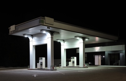 Modern gas station with convenience store beside the road at night