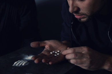 Young addicted man taking drugs, focus on hands